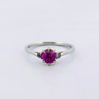 Platina ring med infattning i 18K rödguld, med granat och alexandriter, handgjord lyxdesign mot vit bakgrund.