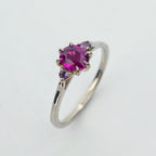 Platina ring med infattning i 18K rödguld, med granat och alexandriter, handgjord lyxdesign mot vit bakgrund.