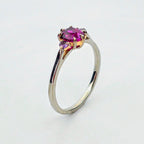 Platina ring med infattning i 18K rödguld, med granat och alexandriter, handgjord lyxdesign mot vit bakgrund.