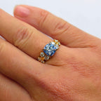 18K Rödguld Moissanite-ring med Ljusblå Centersten och Klusterfattning