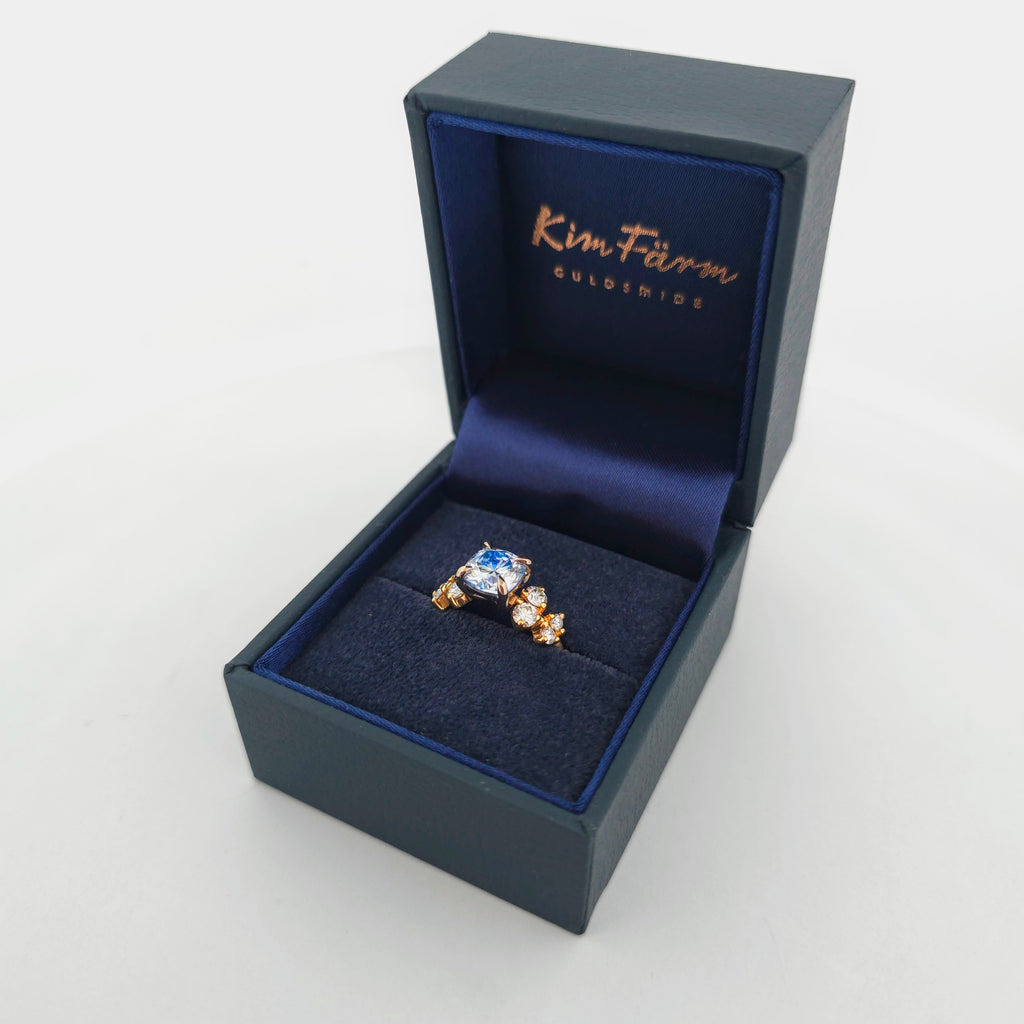 18K Rödguld Moissanite-ring med Ljusblå Centersten och Klusterfattning