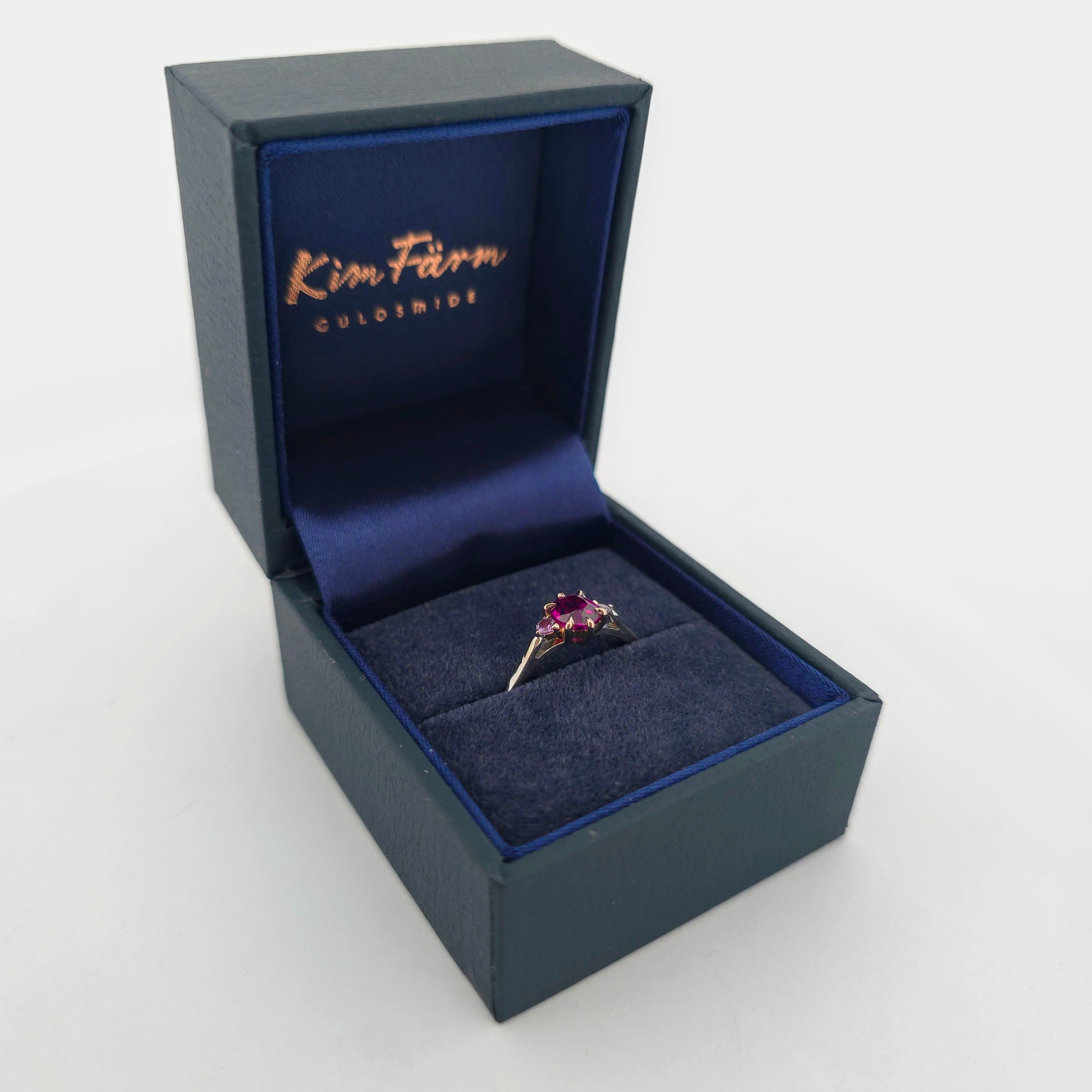 Platina ring med infattning i 18K rödguld, med granat och alexandriter, handgjord lyxdesign mot vit bakgrund.