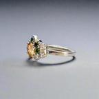 Silverring med orange och gröna moissaniter i elegant handgjord design mot neutral bakgrund.