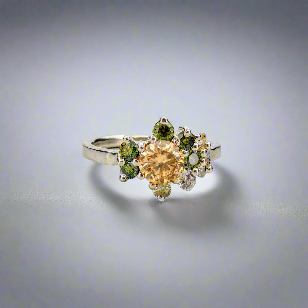 Silverring med orange och gröna moissaniter i elegant handgjord design mot neutral bakgrund.