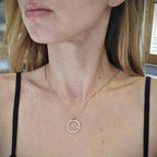 Hänge i 18k rödguld med en cirkelform prydd med vita och rosa moissaniter 