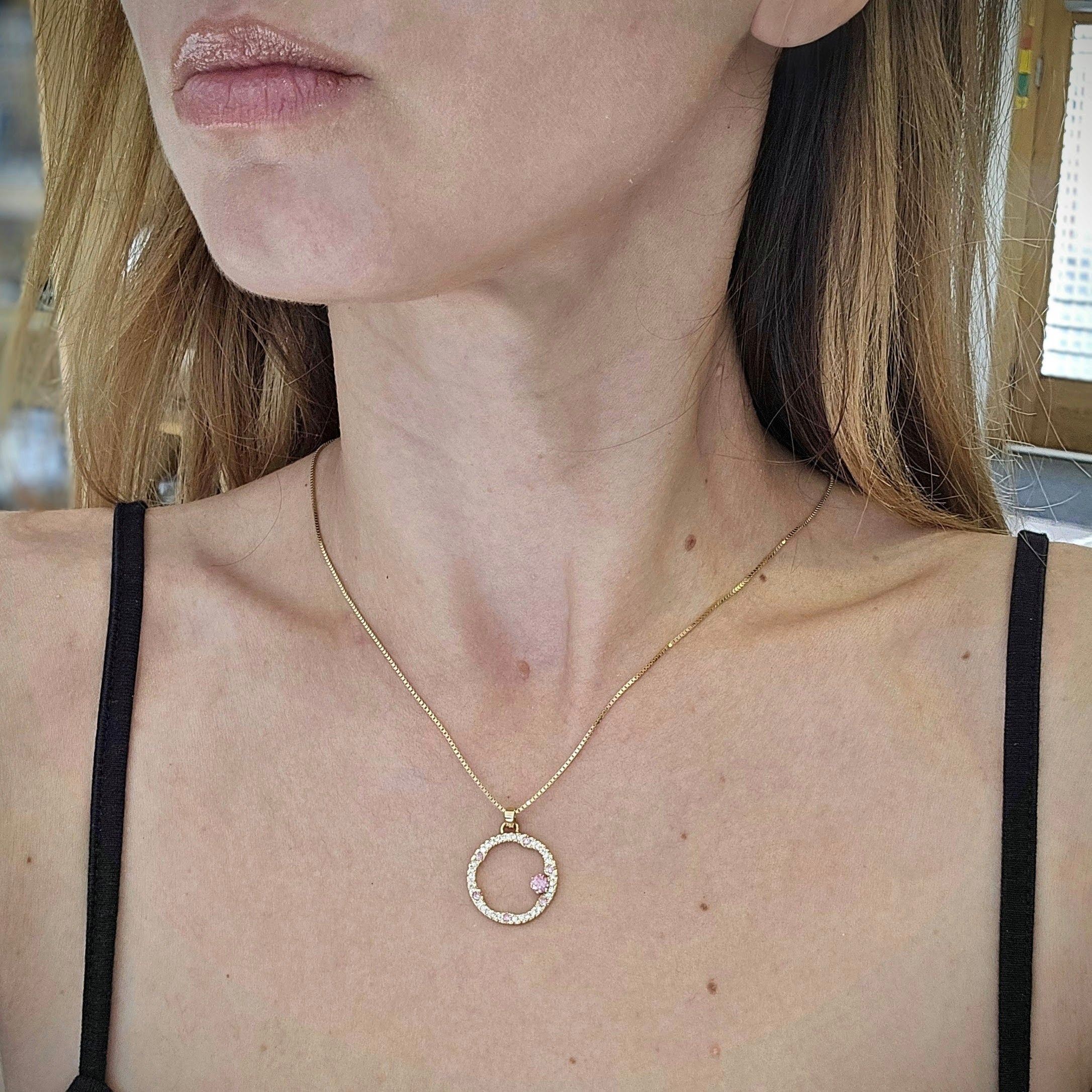 Hänge i 18k rödguld med en cirkelform prydd med vita och rosa moissaniter 