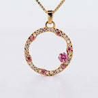 Hänge i 18k rödguld med en cirkelform prydd med vita och rosa moissaniter 