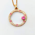 Hänge i 18k rödguld med en cirkelform prydd med vita och rosa moissaniter 