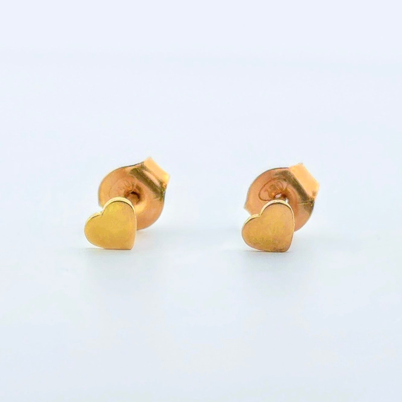 Exklusiva hjärtörhängen i 18 karat guld med elegant, polerad yta – perfekt som romantisk gåva eller lyxig accessoar.
